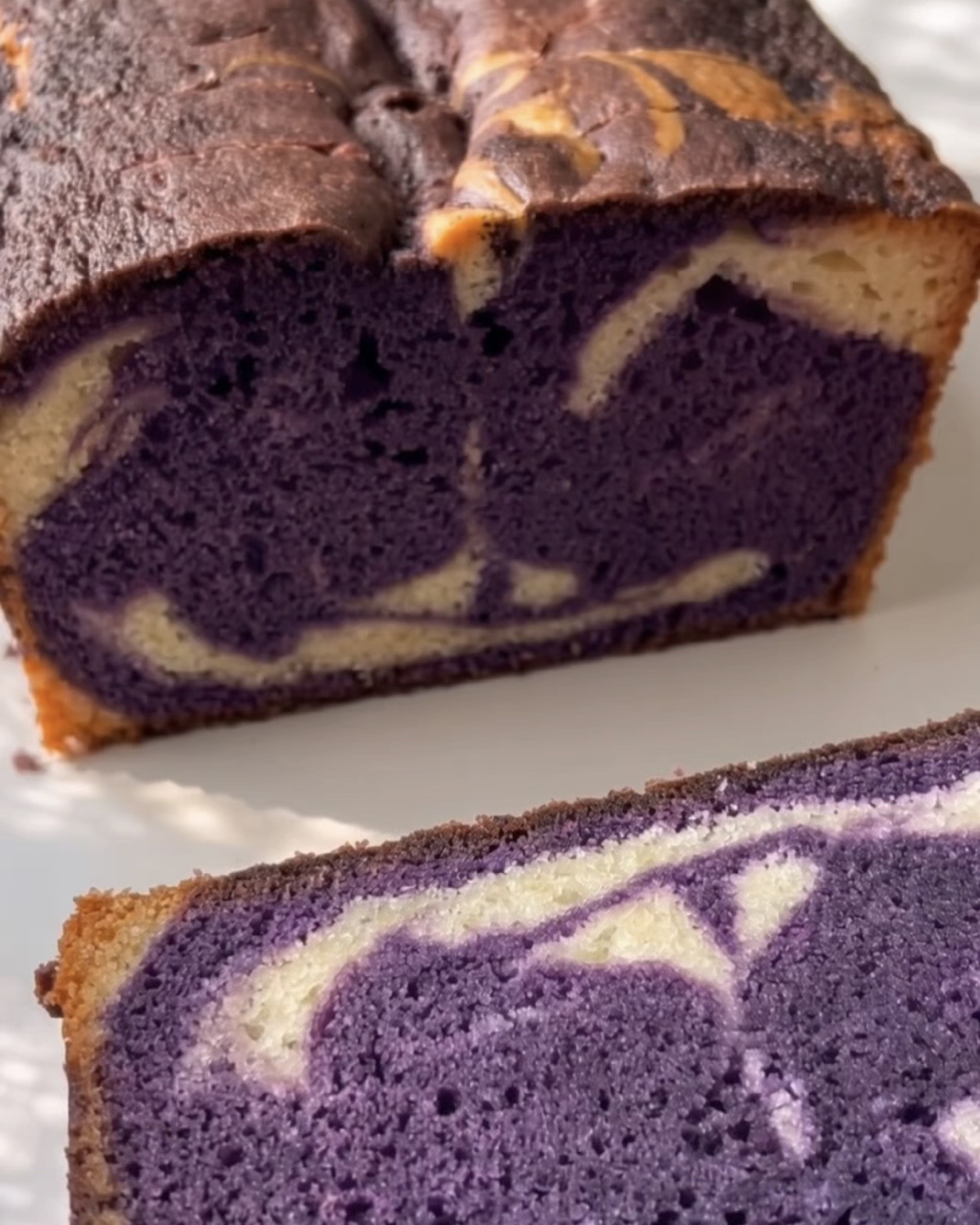 Paistettu ube-marmoripoundkakku leikattu auki, näyttäen violetin ja vaniljan pyörteen, valmistettu Ube Nolia ubejauheista