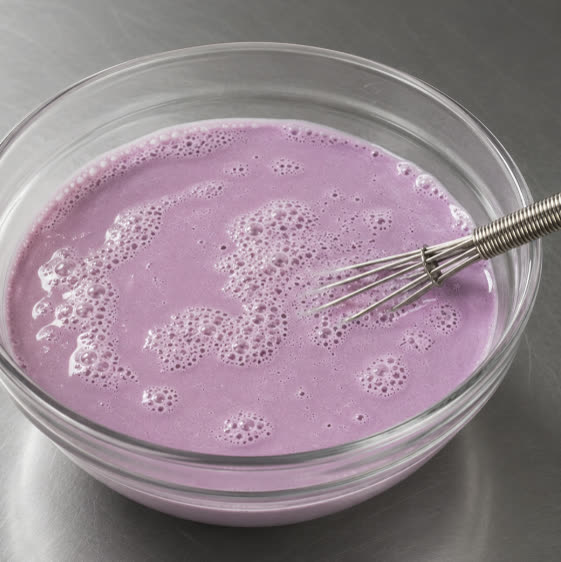 Purple ube milk mixture whisked in a glass bowl | Ube Nolia