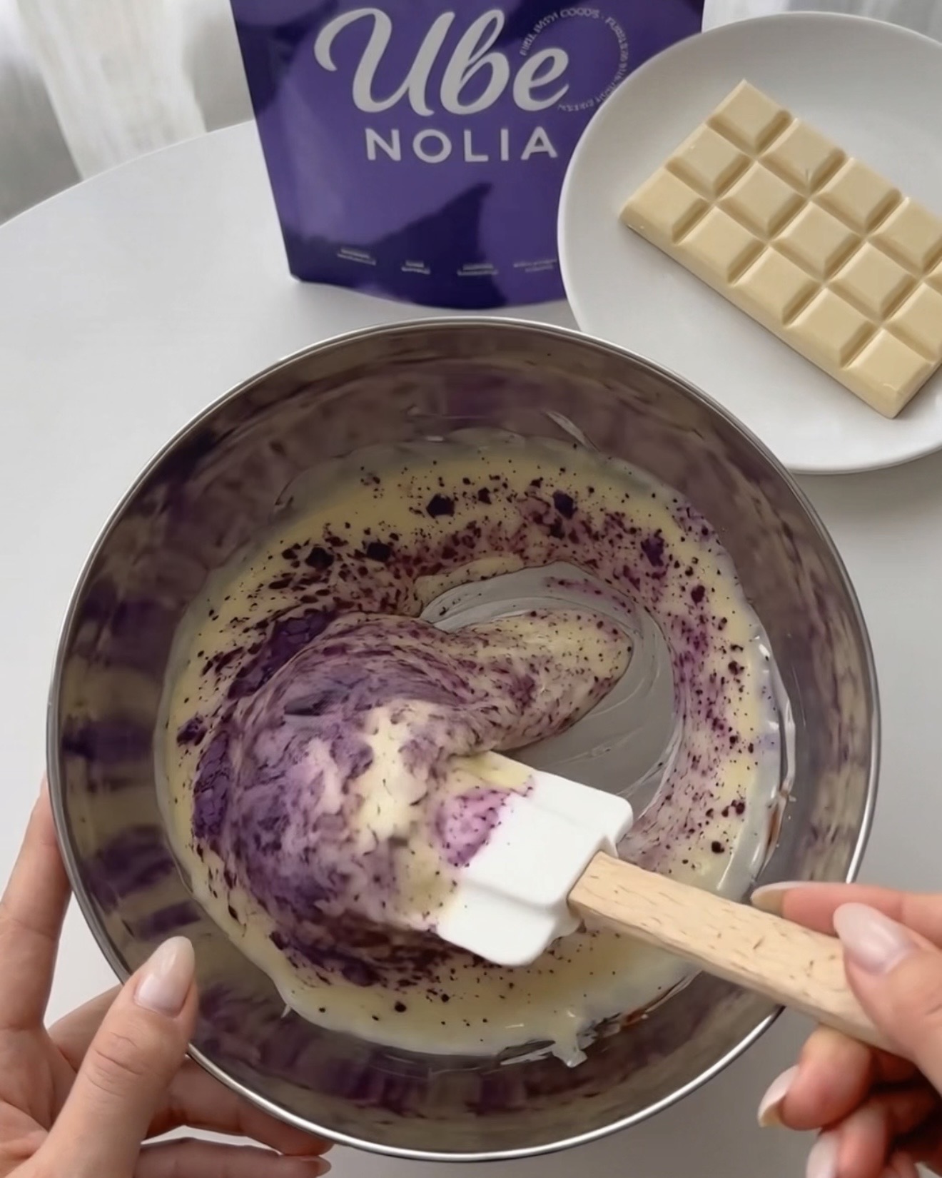Ube Nolia ubejauhe -jauheen vispaaminen sulatettuun valkosuklaaseen violetteja pistaasikinuskipalloja varten